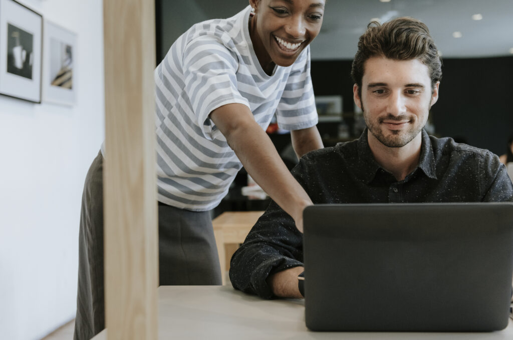 Colleagues discussing their work on a laptop