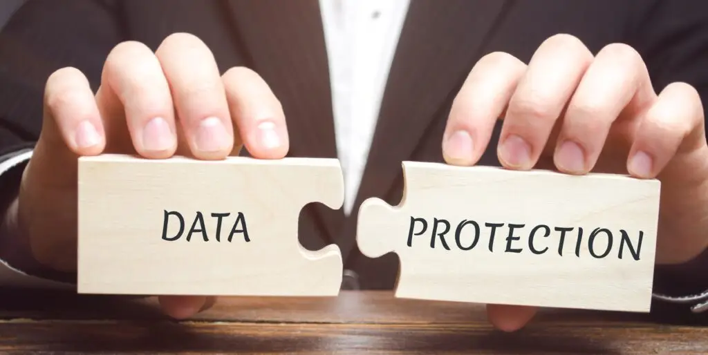 Businessman collects wooden puzzles with the word Data Protection