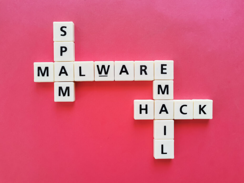 Crosswords malware, spam, email and hack against red background.