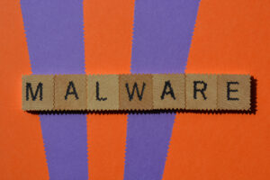 Malware, word in wooden alphabet letters isolated on background with effects added